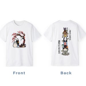 May include: White t-shirt featuring a front graphic of characters from a Japanese animated film, including a large, gray, round creature and a black figure under a tree with pink blossoms. The back has a stacked graphic of other characters and the words "STUDIO GHIBLI".