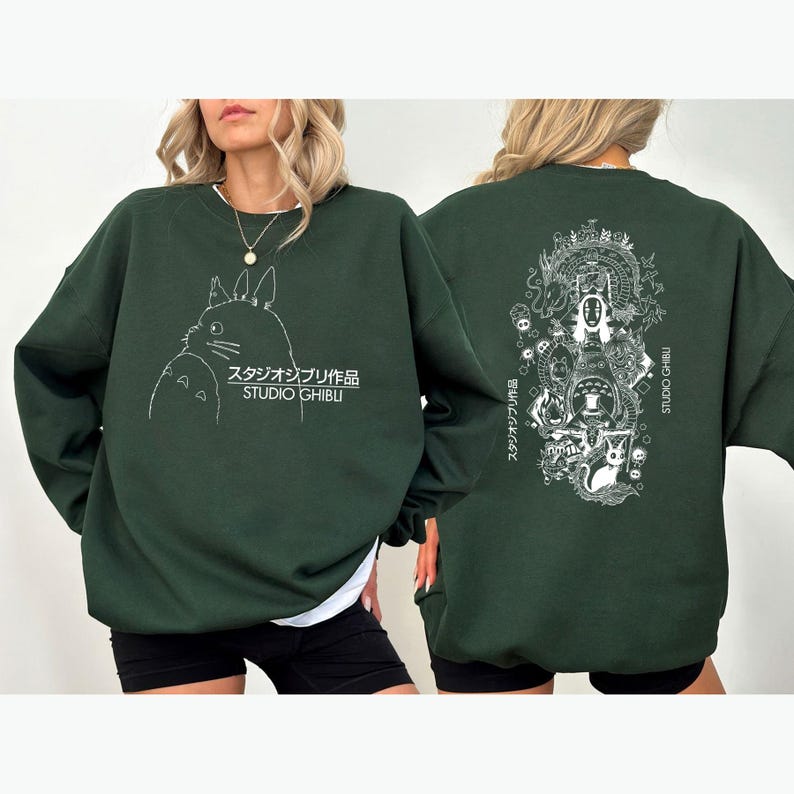 May include: Dark green sweatshirt with a white outline of a cartoon character and Japanese text on the front. The back features a detailed white illustration of characters and Japanese text. The sweatshirt has a crew neck design.