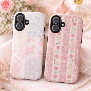 May include: Two phone cases with floral designs. One case features a patchwork pattern with pink and blue floral prints. The other case has vertical stripes with pink flowers. Both cases have black camera cutouts and are set against a soft, floral background.