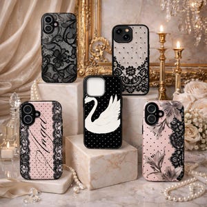 May include: A collection of phone cases with various designs. Some cases feature black lace patterns on black or white backgrounds. Others have pink polka dots with lace trim, one with the word "Angel" and another with a swan illustration.