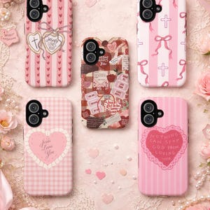 May include: Pink phone cases with various designs, including hearts, crosses, and stripes. Some cases feature the text "Jesus Loves You" and "Nothing Can Stop God From Loving You". The cases are decorated with bows and hearts.