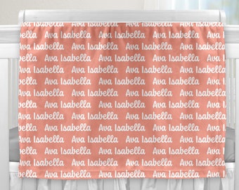 May include: A coral pink baby blanket with the names Ava and Isabella repeated in white text.