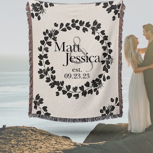May include: A woven throw blanket with a black and white floral design and the text "Matt & Jessica est. 09.23.23".
