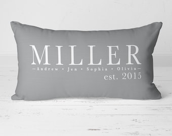 May include: Grey rectangular cushion with white text that reads "MILLER - Andrew - Jen - Sophia - Olivia - est. 2015".