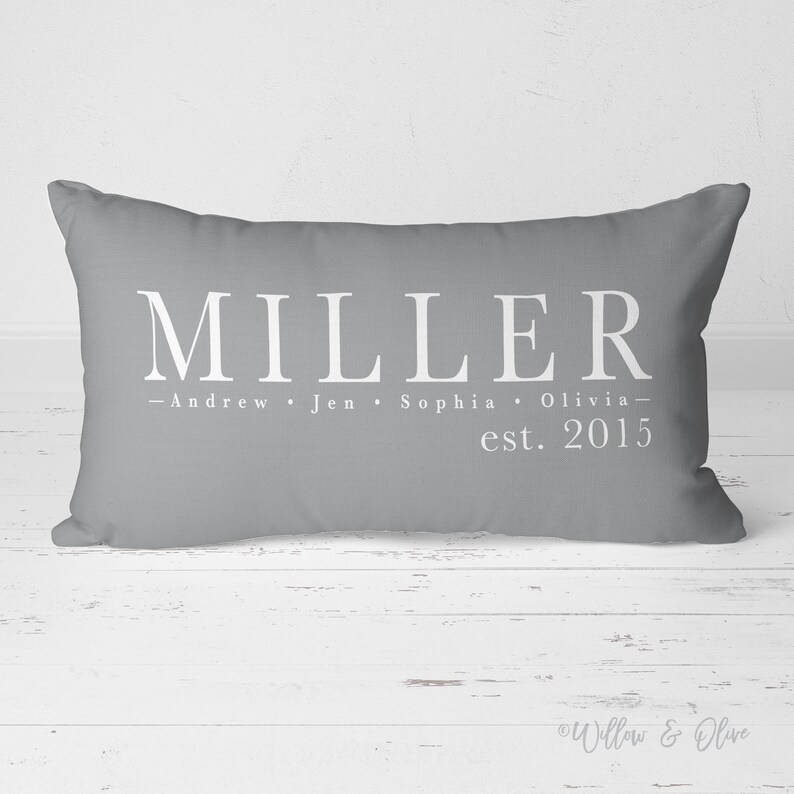 Personalized Family Name and Established Date lumbar throw pillow 20 by 14 inches. Custom last name and first names on lines one and two with established year on line three. Choice of text and background colors. Design printed on both sides.