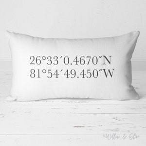 May include: White pillow with black text that reads "26°33'0.4670"N 81°54'49.450"W"