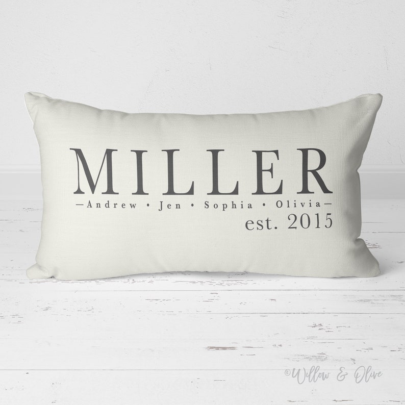 Personalized Family Name and Established Date lumbar throw pillow 20 by 14 inches. Custom last name and first names on lines one and two with established year on line three. Choice of text and background colors. Design printed on both sides.