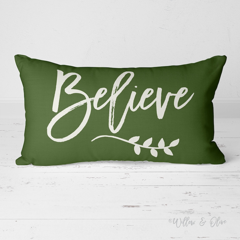 20 by 14 inch lumbar throw pillow with the text Believe accented with a leaf sprig in choice of Christmas Red or Pine Green Colors. Design is printed on both sides of pillow.