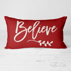 20 by 14 inch lumbar throw pillow with the text Believe accented with a leaf sprig in choice of Christmas Red or Pine Green Colors. Design is printed on both sides of pillow.