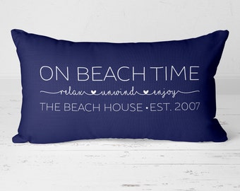 May include: Navy blue rectangular pillow with white text that reads "ON BEACH TIME relax unwind enjoy THE BEACH HOUSE EST. 2007".