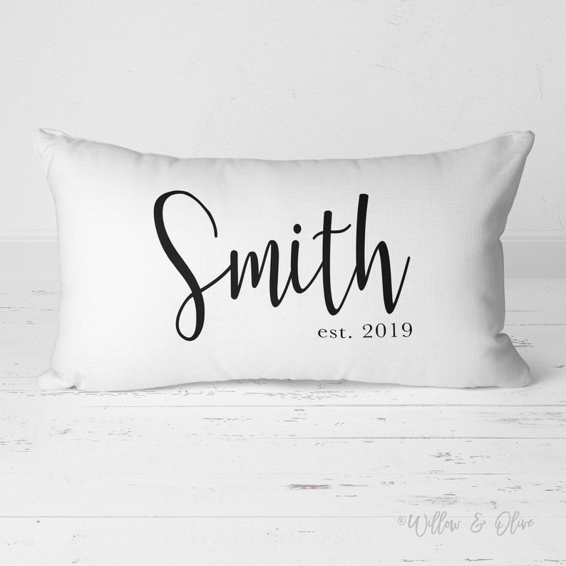 20 by 14 inch lumbar throw pillow personalized with your last name and established year in a fancy script font. Choice of text and background colors. Design is printed on both sides of pillow.