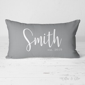 20 by 14 inch lumbar throw pillow personalized with your last name and established year in a fancy script font. Choice of text and background colors. Design is printed on both sides of pillow.