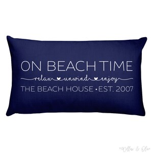 Beach house pillow with quote On Beach Time on first line, then relax, unwind, enjoy on second line in script font. Third line is personalized with your beach house name or family name and established year. Choice of colors for both font and pillow.
