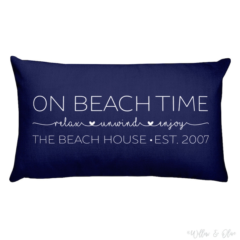 Beach house pillow with quote On Beach Time on first line, then relax, unwind, enjoy on second line in script font. Third line is personalized with your beach house name or family name and established year. Choice of colors for both font and pillow.