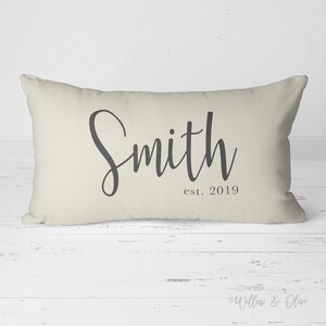 20 by 14 inch lumbar throw pillow personalized with your last name and established year in a fancy script font. Choice of text and background colors. Design is printed on both sides of pillow.