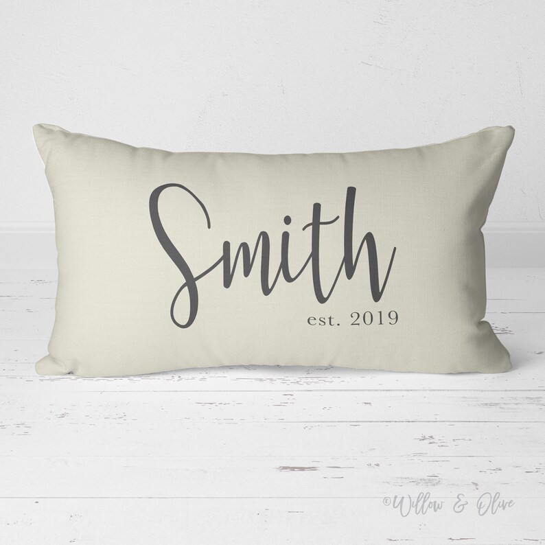 20 by 14 inch lumbar throw pillow personalized with your last name and established year in a fancy script font. Choice of text and background colors. Design is printed on both sides of pillow.