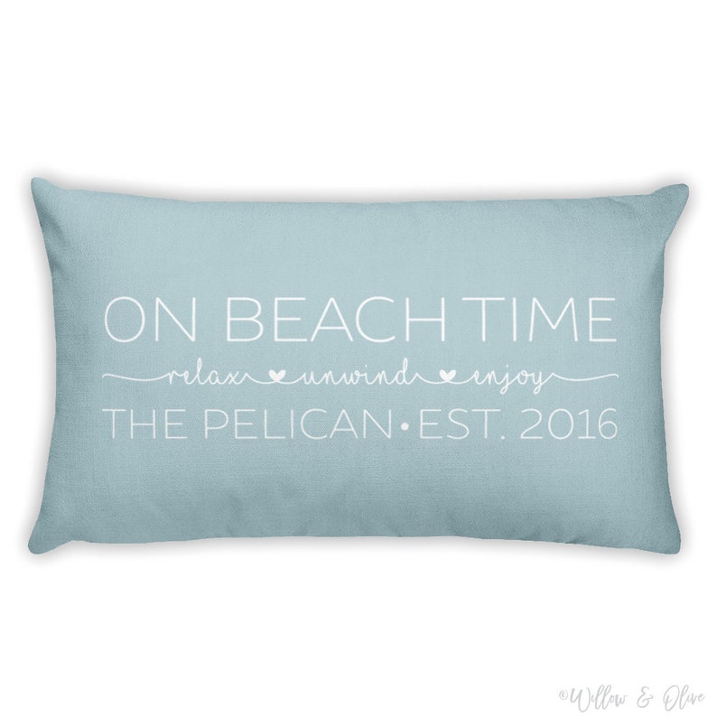 Beach house pillow with quote On Beach Time on first line, then relax, unwind, enjoy on second line in script font. Third line is personalized with your beach house name or family name and established year. Choice of colors for both font and pillow.