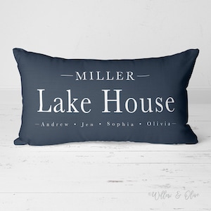 May include: A navy blue throw pillow with white text that reads "MILLER - Lake House - Andrew - Jen - Sophia - Olivia - "