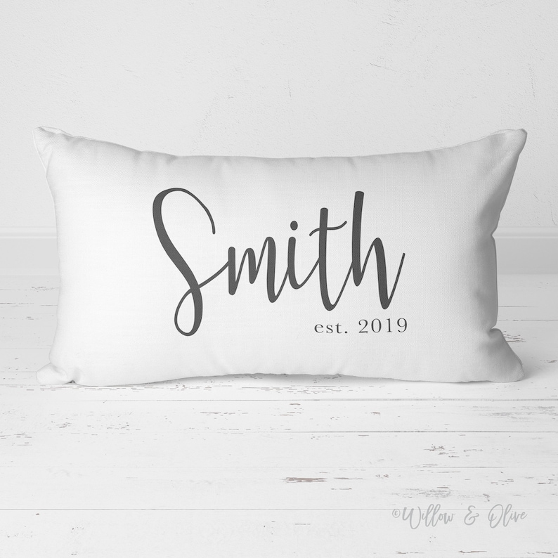 20 by 14 inch lumbar throw pillow personalized with your last name and established year in a fancy script font. Choice of text and background colors. Design is printed on both sides of pillow.