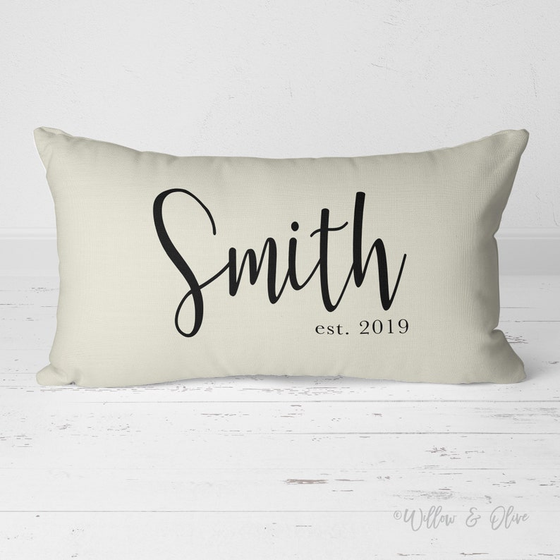 20 by 14 inch lumbar throw pillow personalized with your last name and established year in a fancy script font. Choice of text and background colors. Design is printed on both sides of pillow.