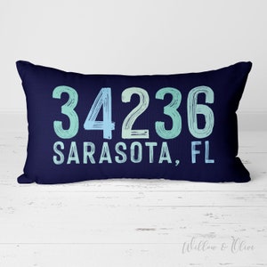 May include: A navy blue cushion with the text "34236 Sarasota, FL" in a blue and green gradient font.