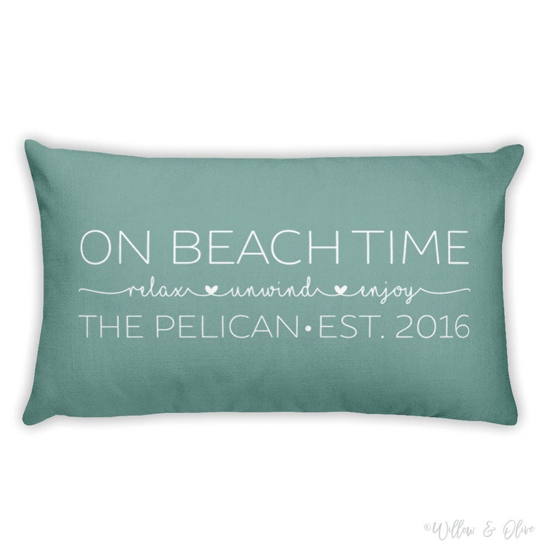 Beach house pillow with quote On Beach Time on first line, then relax, unwind, enjoy on second line in script font. Third line is personalized with your beach house name or family name and established year. Choice of colors for both font and pillow.