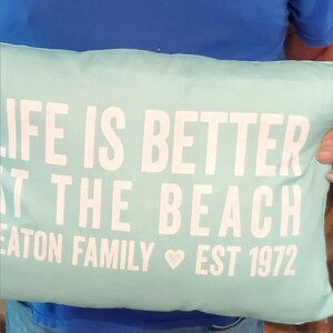 20 by 14 inch personalized lumbar pillow. Life is Better at the Beach text on first two lines. Below that reads your Family last name then the word Family with Established year. Family Name Established Year separated by heart. Custom color choices