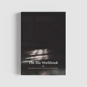 以下が含まれることがあります： 「The Ma Workbook」と書かれた黒いハードカバーの本。タイトルは白で、下にサブタイトルがあります。表紙は、窓から差し込む光のある暗いインテリアシーンを描いています。