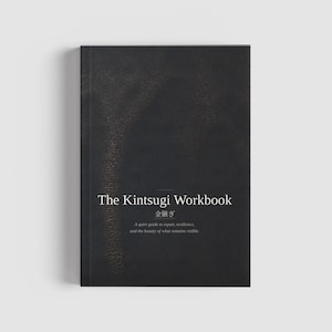 May include: A black workbook titled "The Kintsugi Workbook" with white text. The cover has a textured appearance and includes Japanese characters. The subtitle reads, "A quiet guide to repair, resilience, and the beauty of what remains visible."