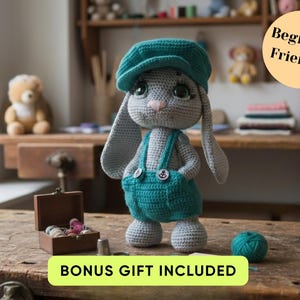 Puede incluir: Muñeca de conejo de ganchillo hecha a mano con gorra y peto turquesa con botones blancos. El conejo gris tiene orejas largas y nariz rosa. La imagen incluye el texto "Beginner Friendly" y "Bonus Gift Included".