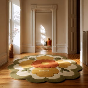 Könnte beinhalten: Ein großer, blütenförmiger Teppich in Grün-, Gelb- und Orangetönen. Der Teppich liegt auf einem Holzboden. Der Text "Bloom Haven IN" ist auf dem Teppich zu sehen.