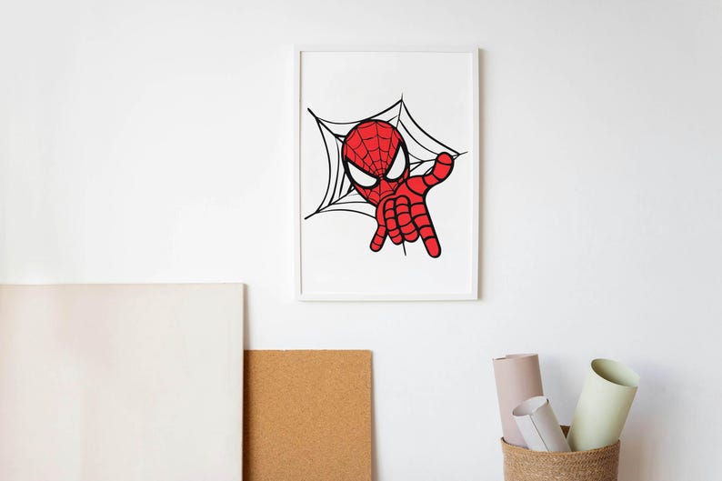 May include: A framed print featuring a cartoon illustration of Spider-Man. The artwork depicts Spider-Man in a red and black suit, with a web design in the background. The image is set against a white wall.