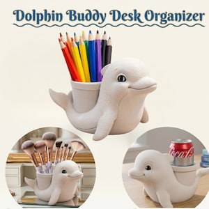 May include: A white dolphin-shaped desk organizer with a cylindrical holder. The organizer is shown holding colored pencils, makeup brushes, and a soda can. The text "Dolphin Buddy Desk Organizer" is arched above the dolphin.