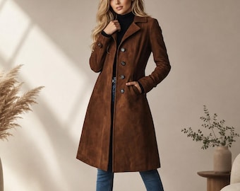May include: A knee-length brown suede coat with a notched collar, long sleeves, and a single-breasted button front closure. The coat is worn over a black mock-neck top and blue denim jeans, paired with dark brown leather ankle boots.