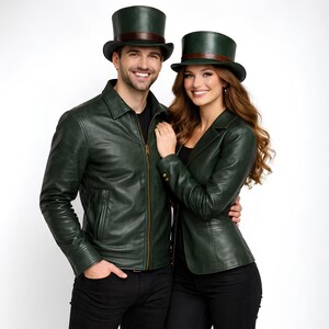 Op de afbeelding: Een stel draagt bijpassende bosgroene leren jassen en hoge hoeden met bruine banden. De man draagt een jas met ritssluiting en de vrouw een blazer. Beide dragen zwarte broeken.