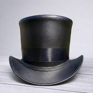 May include: A black top hat with a wide brim and a black band around the crown. The hat is made of a smooth, possibly leather, material. The hat is a classic formal accessory.