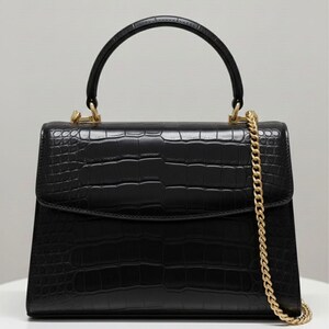 May include: A black handbag with a crocodile-effect texture. It features a top handle and a gold chain strap. The bag has gold-toned hardware and a rectangular shape with a flap closure.