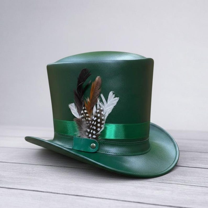Puede incluir: Un sombrero de copa verde oscuro con una cinta de sat&eacute;n y un grupo de plumas decorativas. El sombrero tiene un ala ligeramente curvada y una copa cil&iacute;ndrica alta. Las plumas son negras, marrones y blancas.