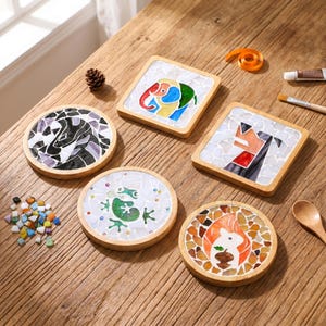 Pode incluir: Cinco porta-copos com molduras de madeira e designs de mosaico com um elefante, uma raposa, um sapo, um esquilo com uma bolota e um padrão abstrato em preto e branco. O conjunto inclui peças de vidro soltas, um pincel e cola.