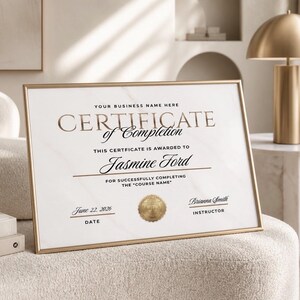 May include: A framed certificate of completion with gold lettering and a gold border. The certificate is awarded to Jasmine Ford and dated June 22, 2026. The text includes "Your Business Name Here" and "For Successfully Completing the 'Course Name'".