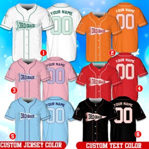 Pode incluir: Uma coleção de seis camisas de beisebol com botões nas cores branca, laranja, rosa, vermelha, azul clara e preta. Cada camisa apresenta um gráfico frontal de uma flâmula com o texto 3RD GRADE e um design traseiro com o texto YOUR NAME e 00.