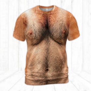 Peut inclure: Un t-shirt à manches courtes et col rond arborant une impression photographique réaliste et haute définition d'un torse humain poilu. Le motif présente des tons de peau avec des poils foncés sur la poitrine et l'abdomen, incluant des tétons et un nombril visibles.