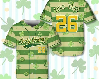 May include: Green and tan baseball jersey with shamrock and stripe pattern. The jersey has the text "Lucky Charm" and the number "26" on the front. The back of the jersey has the text "YOUR NAME" above the number "26".