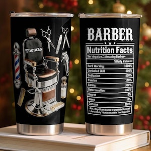 May include: A set of three ceramic mugs with a speckled, cream-colored glaze. Each mug features a different hand-painted design: a blue and green leaf, a yellow flower, and a red berry. The mugs have a simple, rounded shape.