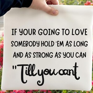 May include: A white rectangular pillow with black text that reads "IF YOUR GOING TO LOVE SOMEBODY HOLD 'EM AS LONG AND AS STRONG AS YOU CAN "Till you cant". The bottom of the pillow has the words "PNG", "SVG", and "DIJITAL".