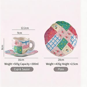 K&ouml;nnte beinhalten: Ein Keramik-Tassen- und Untertassen-Set im Patchwork-Stil mit passendem Teller. Die Tasse ist 8 cm hoch, die Untertasse 16 cm breit und der Teller hat einen Durchmesser von 20 cm. Das Set hat rosa, gr&uuml;ne und blaue Patches.