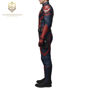 May include: A blue and red leather suit with a high collar, shoulder pads, and a utility belt. The suit has red accents and a black pouch on the leg. The boots are black. The logo of Noir Empire Leather is in the top left corner.