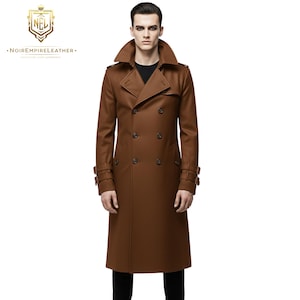 Könnte beinhalten: Ein brauner, doppeltbreit gefasster Trenchcoat mit breitem Kragen und Knöpfen. Der Mantel hat eine lange Länge und verfügt über ein Gürteldetail an den Ärmeln. Das Markenlogo ist oben links sichtbar.