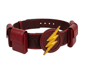 May include: A dark red utility belt featuring a circular buckle with a prominent yellow lightning bolt emblem. The belt includes two attached rectangular pouches on either side and a series of adjustment holes along the back strap.