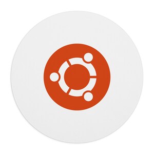 Puede incluir: Una pegatina circular blanca con el logotipo naranja de Ubuntu en el centro. El logotipo consta de tres figuras blancas estilizadas dispuestas en círculo, conectadas por un anillo blanco, sobre un fondo circular de color naranja sólido.
